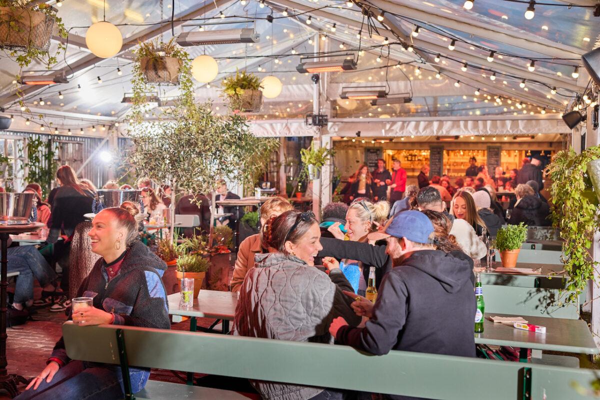 Peckham Arches outdoor oasis with twinkling lights and people enjoying drinks