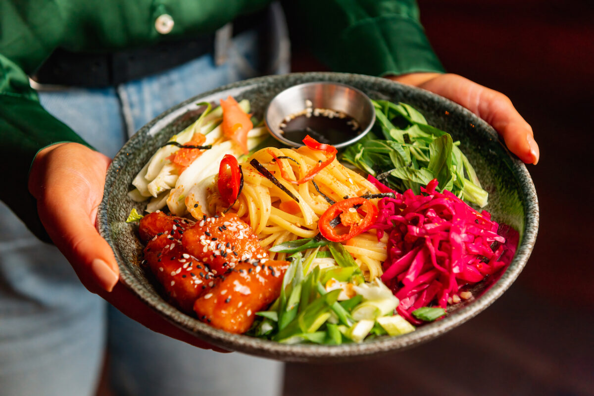 A food dish being carried to a table by a waiter at Manhatta Newcastle