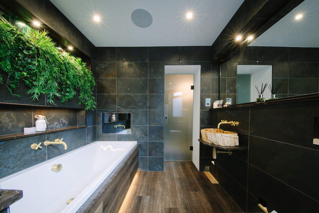 The sizeable Oasis bathroom with integrated TV at Absoluxe Suites