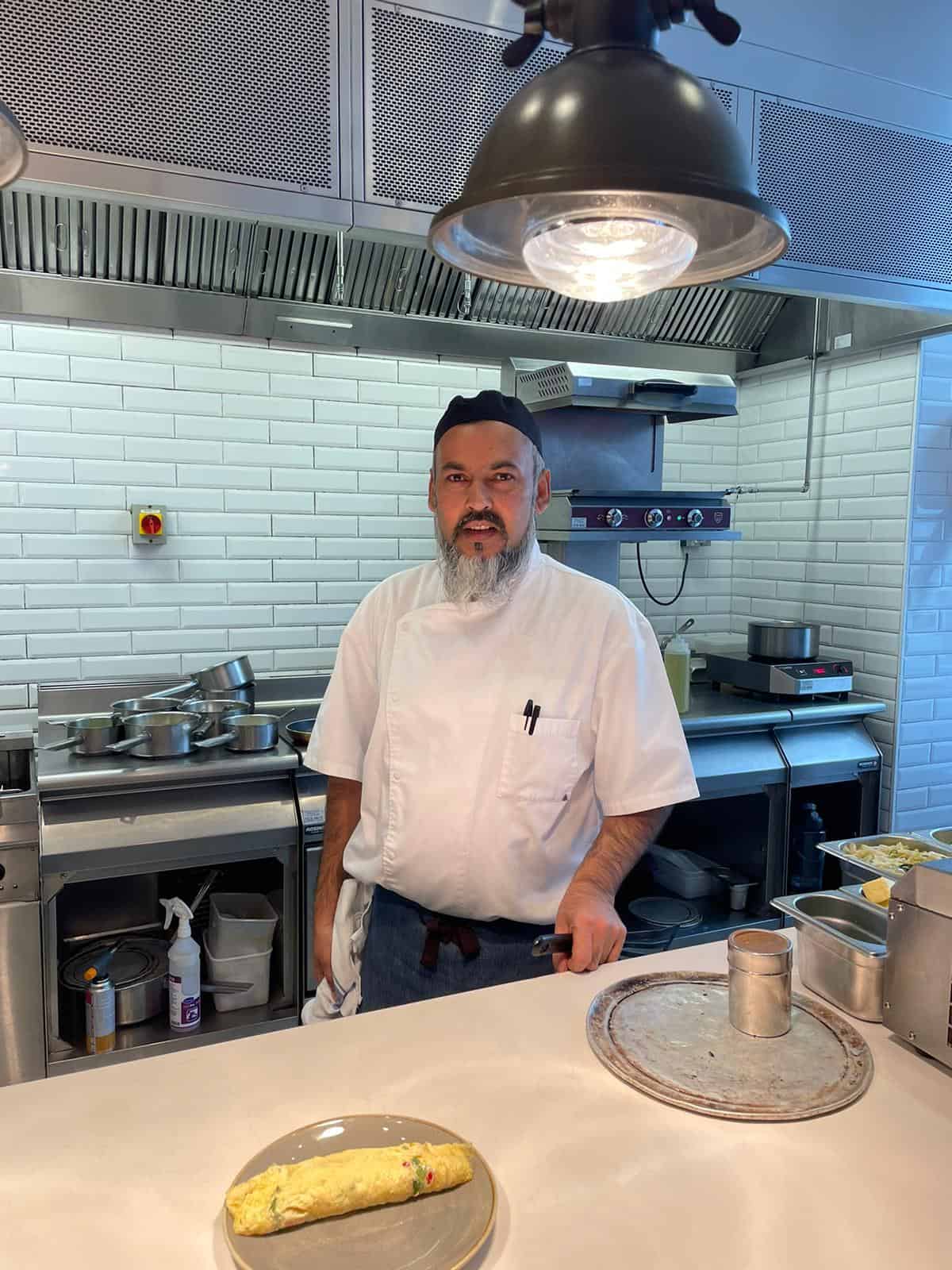 Chef Ali whipping up perfectly cooked omelettes in the kitchen at Oxbo!