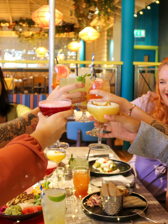 Friends saying cheers over their cocktails at Turtle Bay