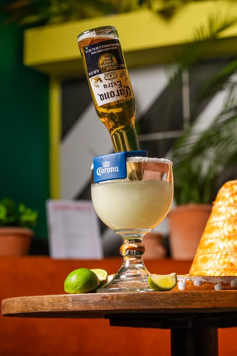 A bottle of Corona Extra being poured into a big glass at Motel Mexicana