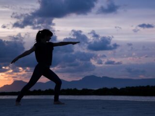 The Best Wellbeing and Fitness Holiday Destinations - beach yoga woman