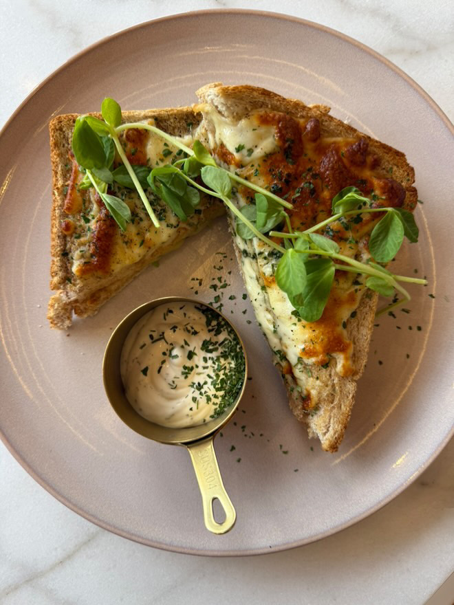A toastie cut in half, topped with salad from Lily Brew Jesmond