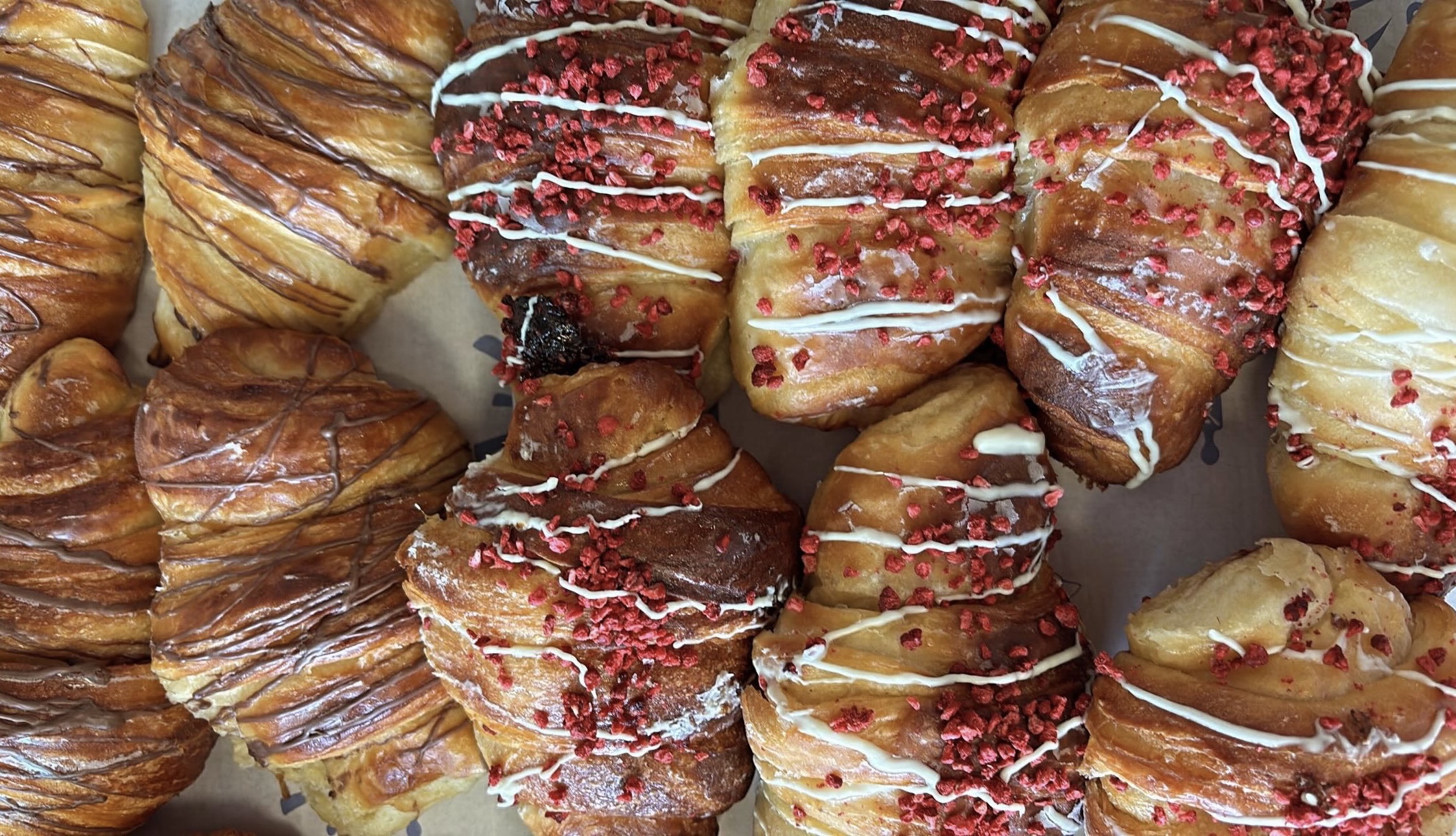 A batch of croissants drizzled in icing and decorated at Batch Bakery Newcastle
