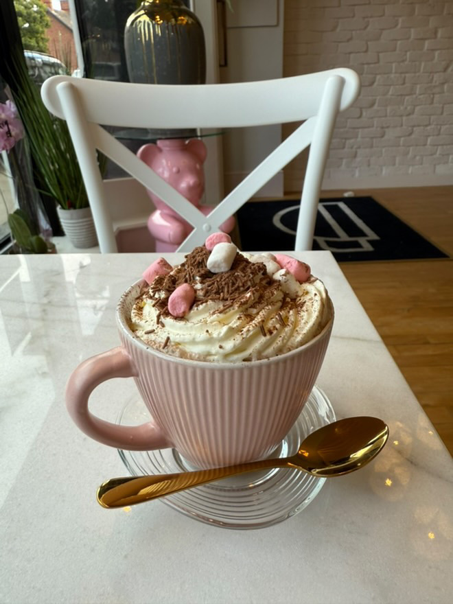 A pink mug filled with a hot chocolate, topped with whipped cream and pink marshmallows at Lily Brew Jesmond