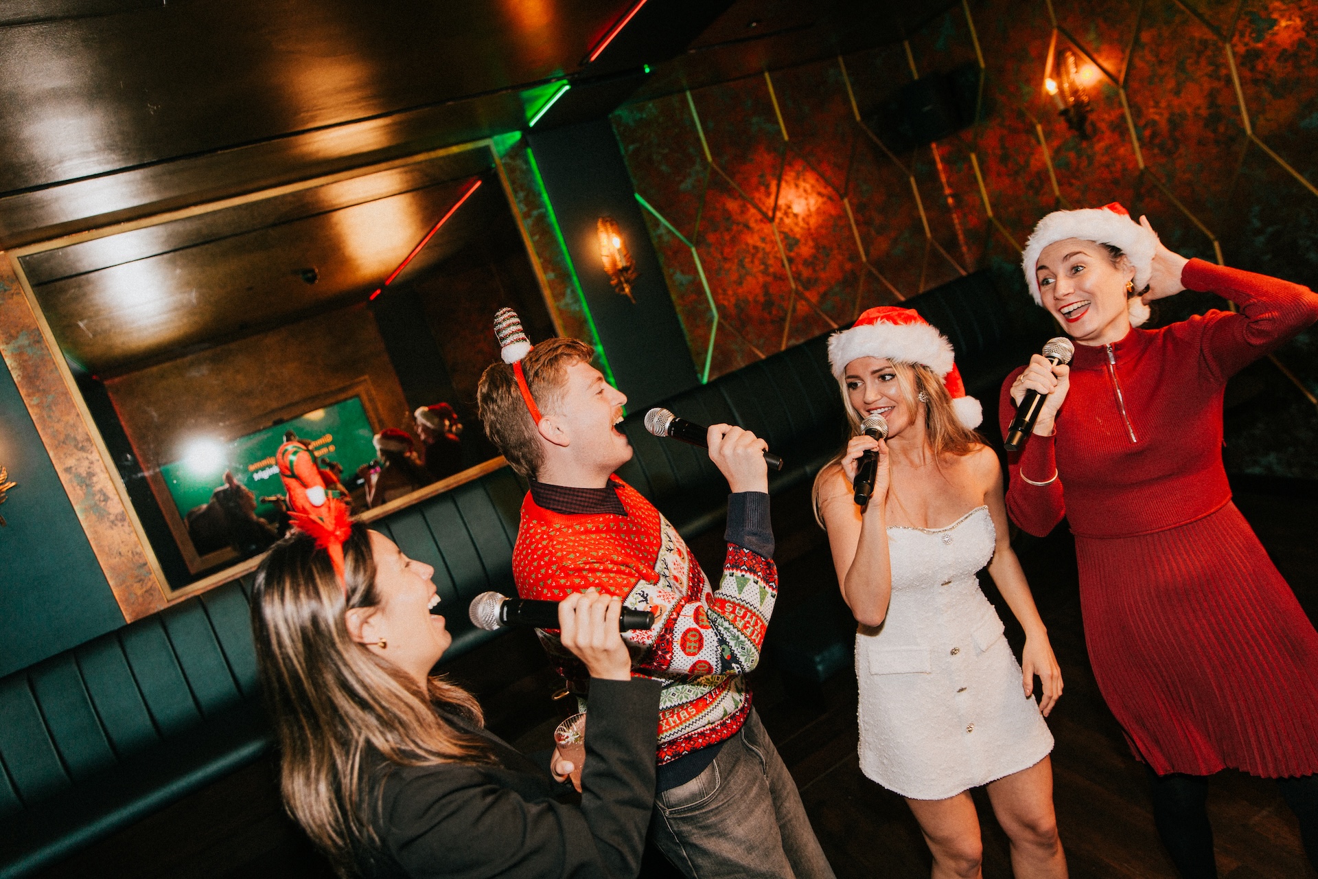 four friends dressed in christmas outfits singing at BAM Karaoke