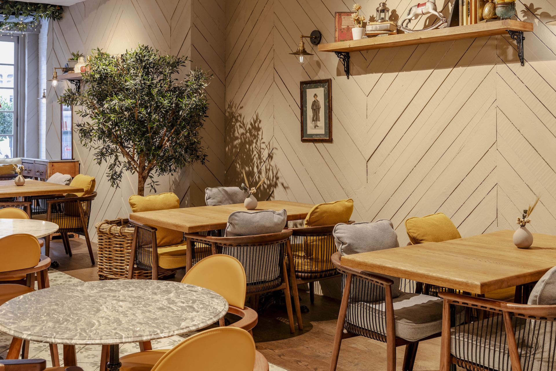 L'ETO Brompton Road interiors featuring a standing tree and yellow and grey seating
