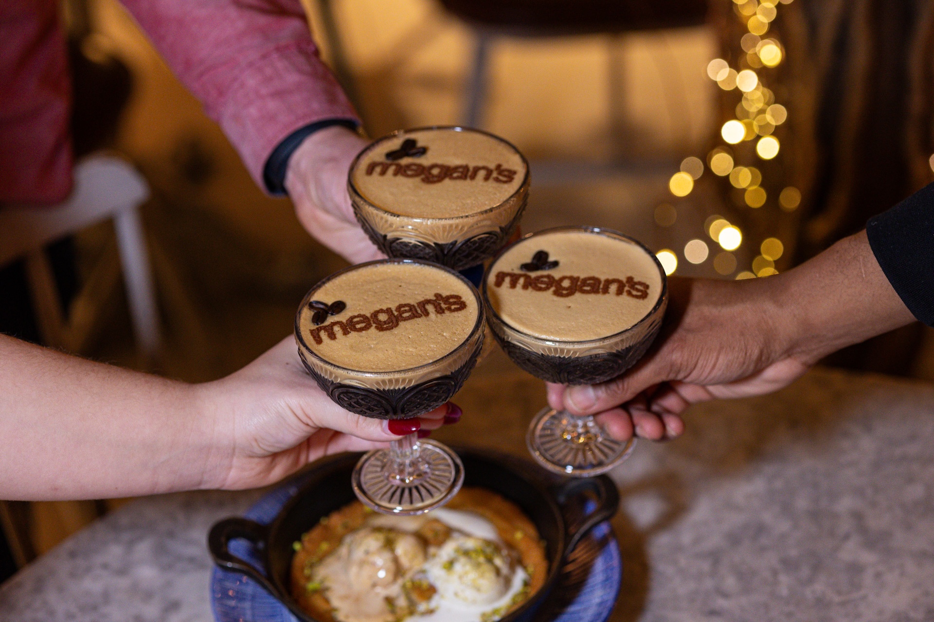 3 espresso martinis with megan's written in the foam on top